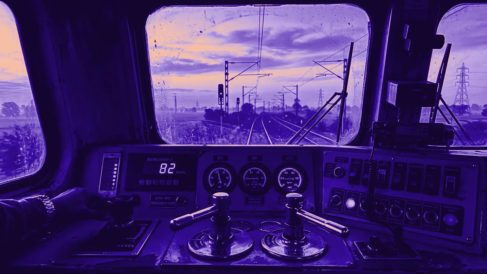 Assistant Loco Pilot operating dual brass brake levers and console throttles inside electric WAP-7 locomotive dashboard console at dawn